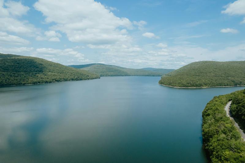 Aerial view of Pepacton Reservoir between green hills under a blue sky
